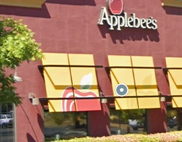 Exterior view of an Applebee's restaurant with red walls, yellow window awnings, and the Applebee's logo visible above the windows.