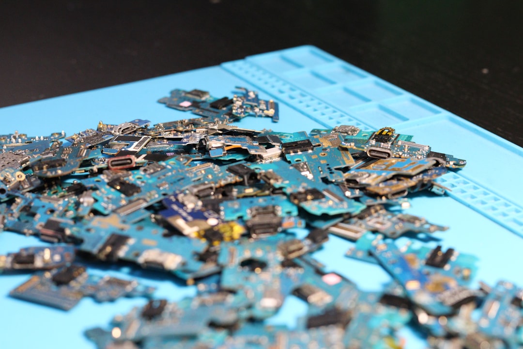 A pile of disassembled electronic circuit boards and components laying on a blue mat.